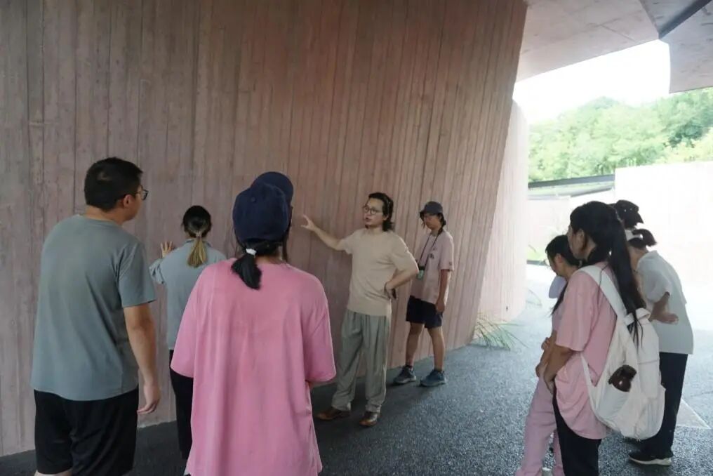 图为带队老师向实践团成员介绍鸟舍详情
