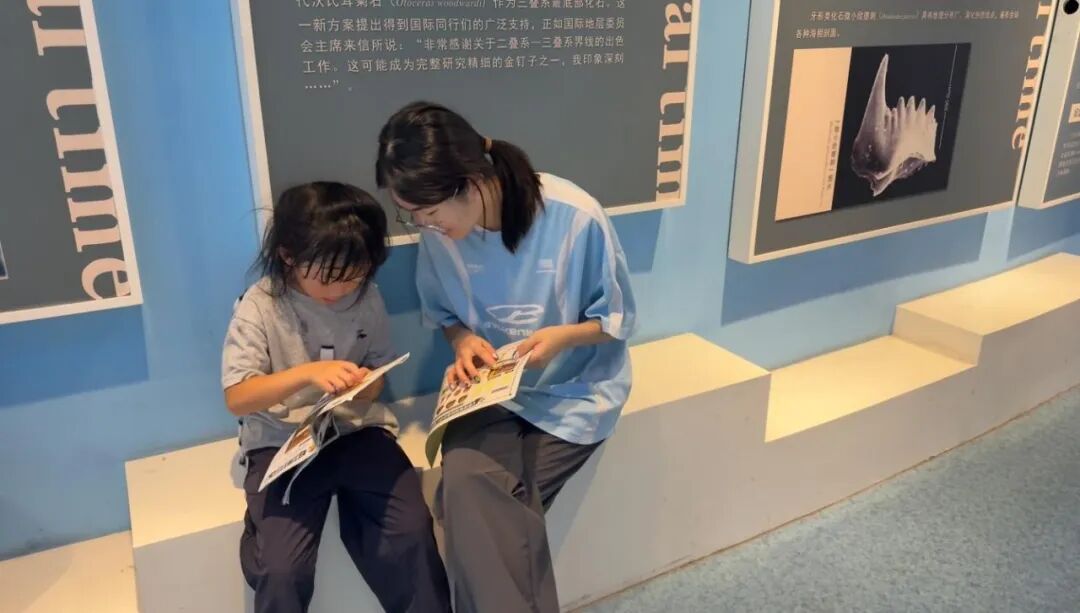实践团成员陪伴小游客阅读科普手册
