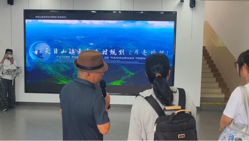 图为讲解员介绍村庄发展规划