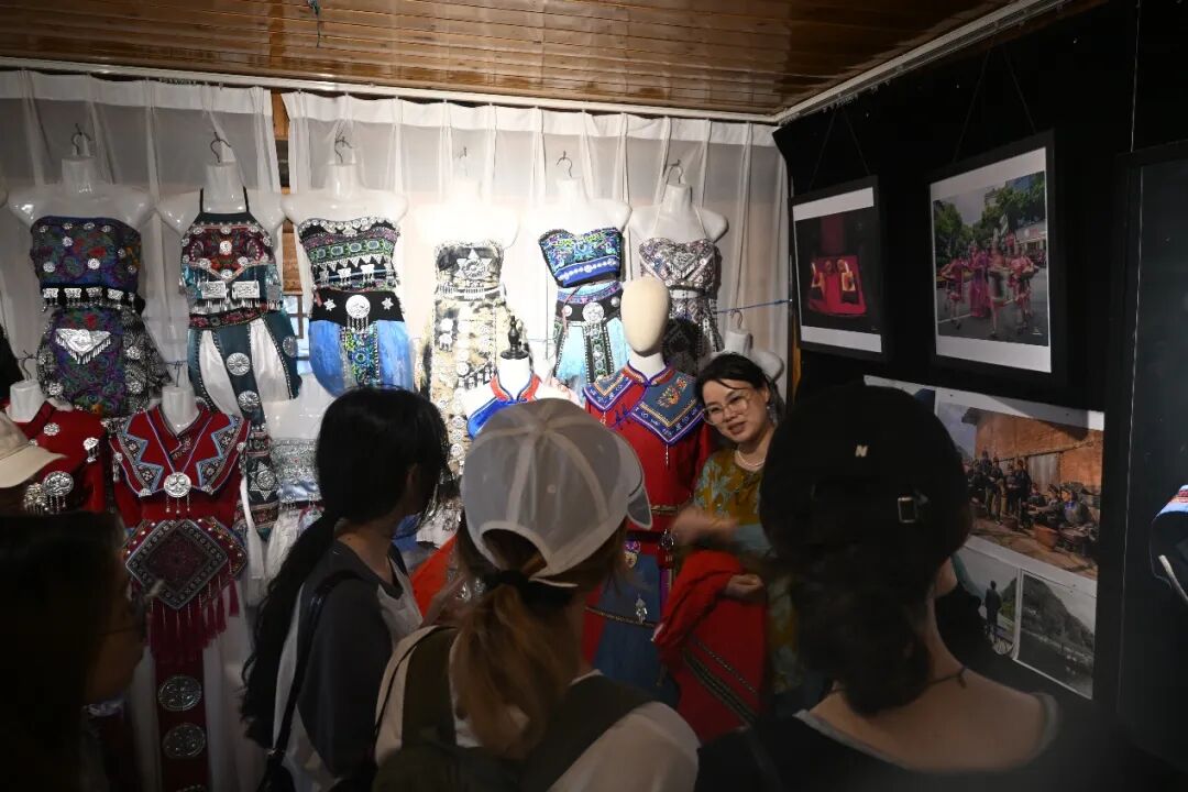 图为实践团成员听讲解员介绍畲族文化服饰