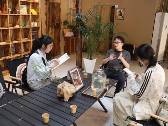 图为咖啡店负责人介绍黄林坑村咖啡店的发展