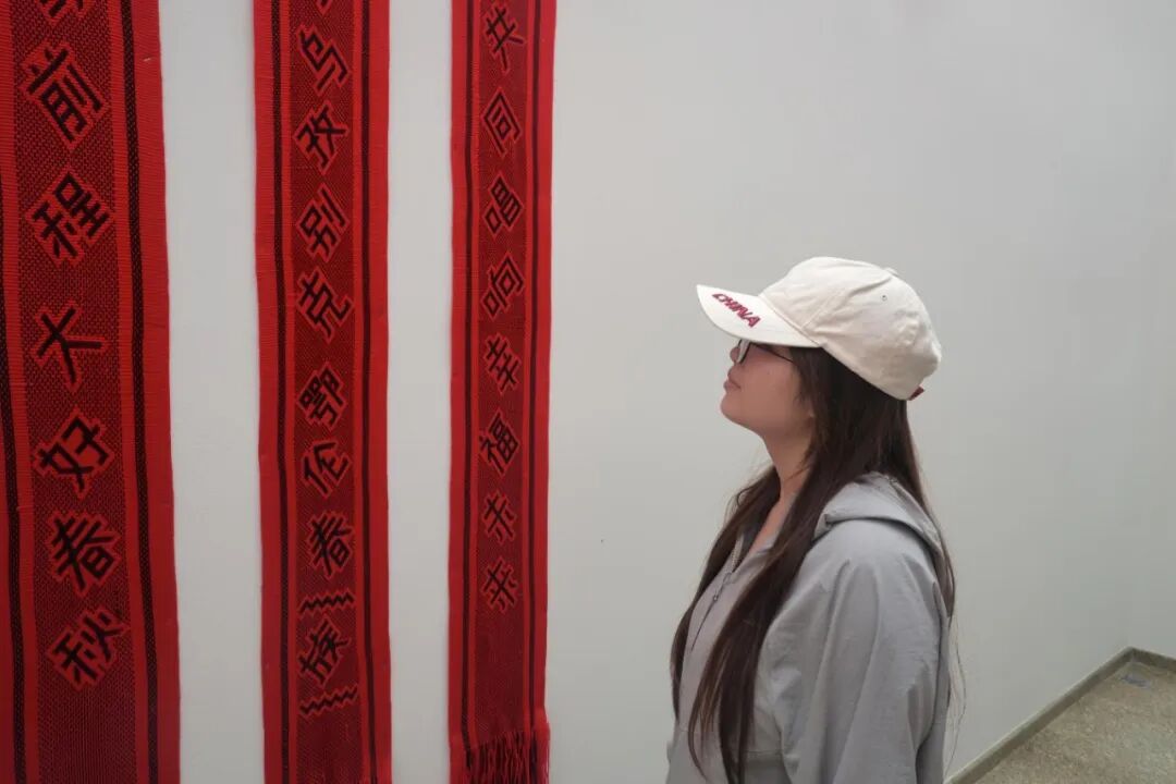 图为实践队员观看馆内馆藏畲族彩带、传统服饰展品