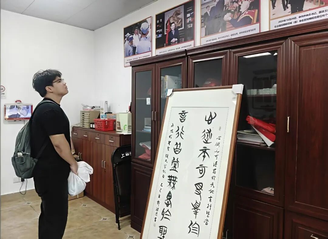 实践团成员在上田村村委品读钱氏家训书法作品