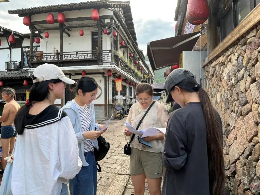 图为团队成员与青年旅客交流古村游览体验