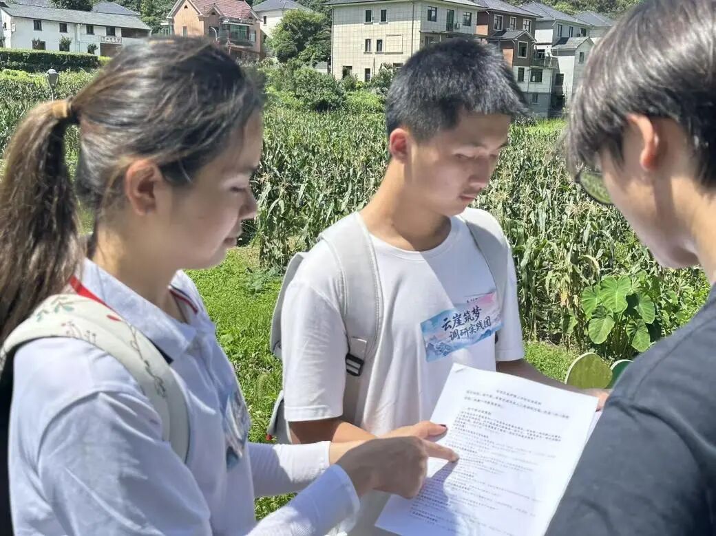 图为实践团队成员核对调研问卷并记录村庄走访信息