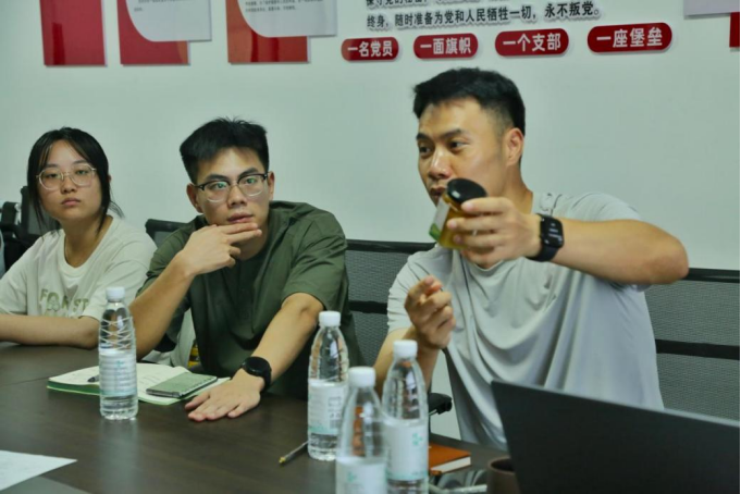 图为开化县两山集团负责人为实践团成员展示蜂蜜产品
