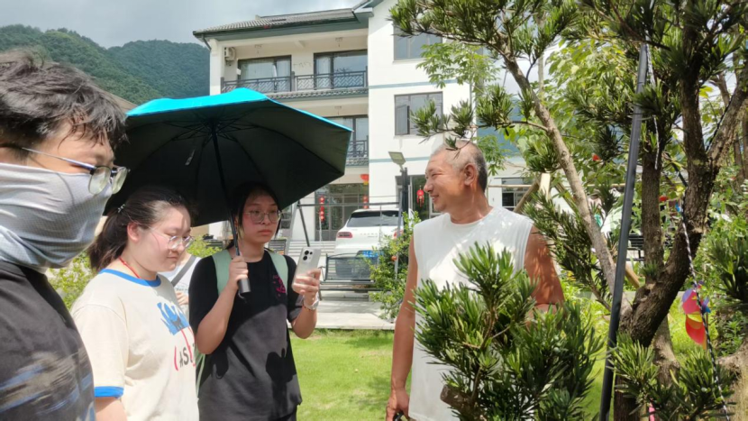 图为团队在听民宿老板讲解植物布置理念