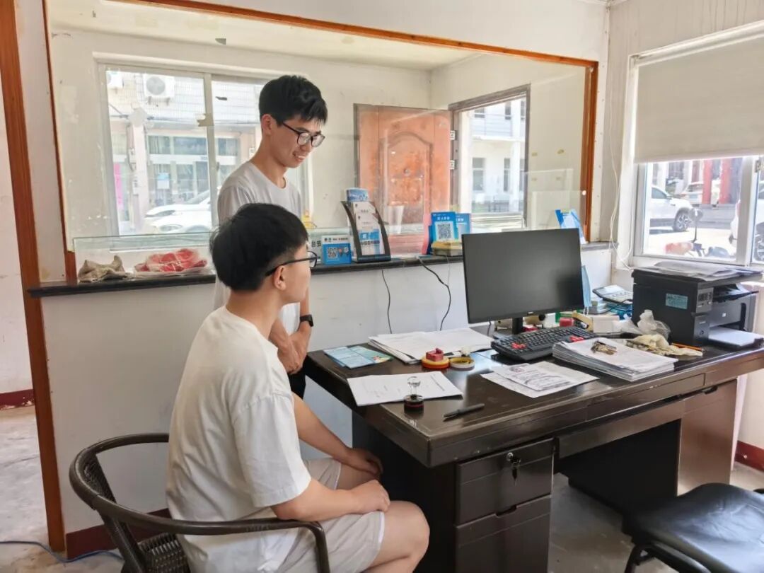 图为实践团成员与村“两委”干部交流