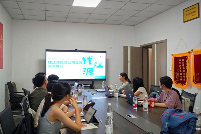 图为开化县钱江源发展有限公司负责人为实践团成员介绍品牌