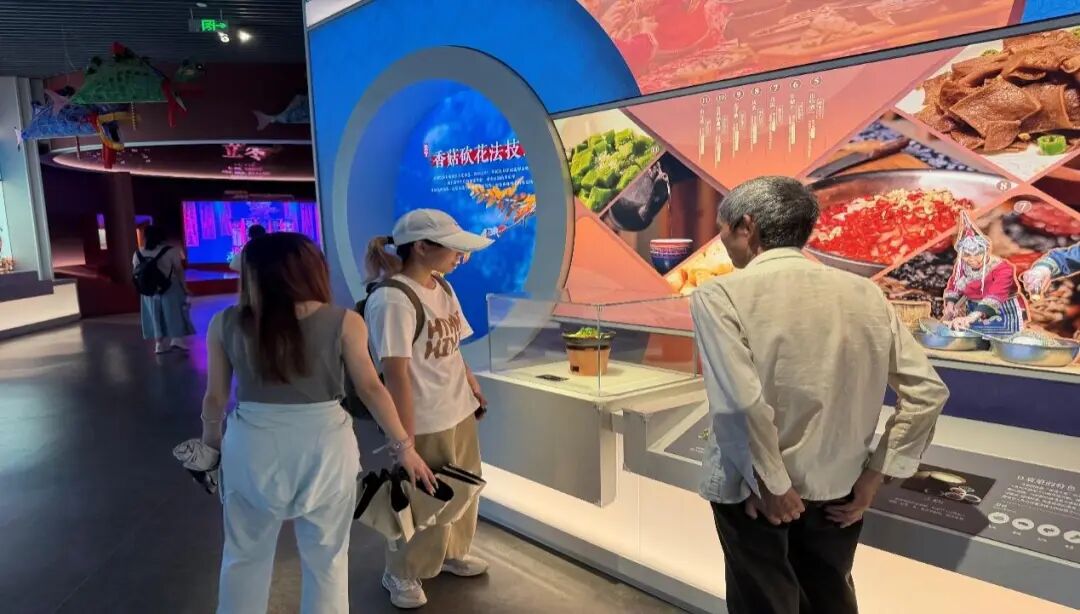 图为实践团成员听讲解员讲述畲族特色美食