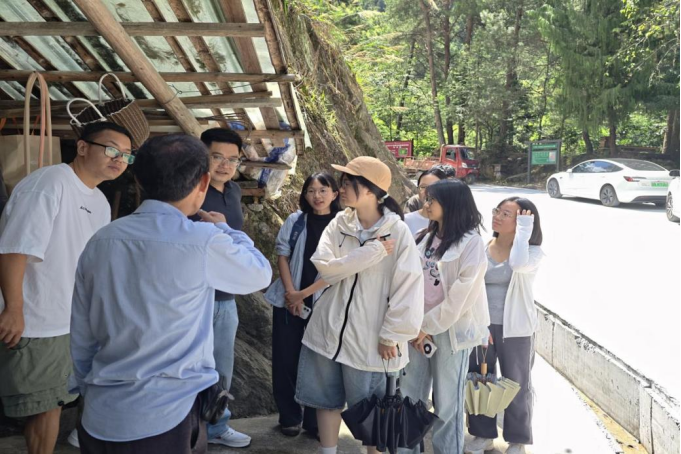 图为齐溪镇养蜂农郑祥全向实践团成员介绍蜂场情况